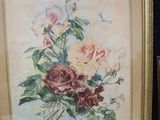 two framed paintings of flowers on display in a glass case