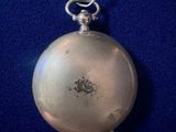 an old silver pocket watch with a chain hanging from it ' s side