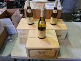 trois bouteilles de vin posées sur des cartons, sur une table