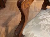 a wooden chair with a white upholstered cushion on it