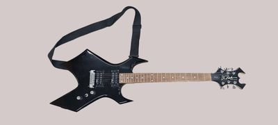 une guitare électrique à laquelle est accrochée une sangle au niveau du manche