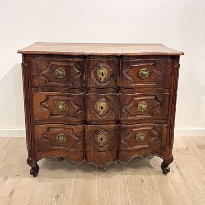 une commode ancienne avec des poignées en laiton et un plateau en bois