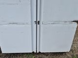 two old refrigerators sitting in the yard next to each other