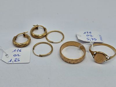 several gold rings and a tag on a white surface