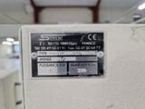 une image représentant une machine dans une usine, sur laquelle est accrochée une pancarte