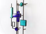 a sculpture made of glass bottles on a metal stand