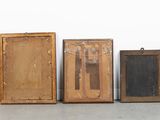 three old wooden frames are lined up against a white wall