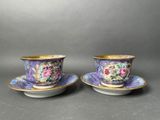 a pair of cups and saucers with floral designs on them