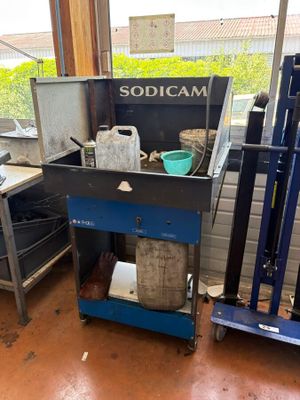 a blue cart with a metal container on it in a room