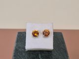 a pair of earrings sitting on top of a marble block