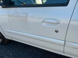 une petite voiture blanche dont la vitre et la poignée de porte sont sales