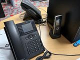 un bureau sur lequel se trouvent un téléphone, un ordinateur portable et un autre téléphone