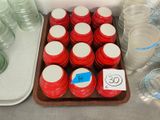 many jars of water on a table with labels on them