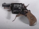 un petit pistolet posé sur une surface blanche