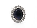 gros plan d'une bague avec une pierre bleue entourée de diamants