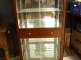 a glass display case in the corner of a room