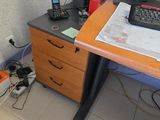 a desk with a computer, keyboard, and a phone on it