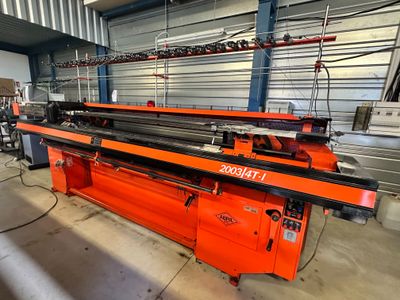 an orange machine is sitting in a warehouse with other machines
