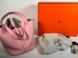 an orange box with a pink handbag and a white bag