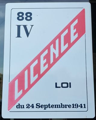 une affiche sur la vitrine d'un immeuble sur laquelle on peut lire « licence »