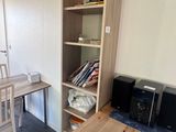 a table and a chair in a room with a bookcase