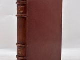 a brown book sitting on top of a white surface