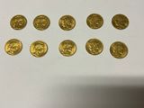 a bunch of gold coins sitting on top of a white table