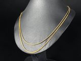 un collier à chaîne en or sur un mannequin, sur fond noir
