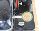 a black sewing machine with a red handle on a wooden table