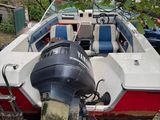 a white and red boat that is parked in the grass