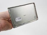someone is holding a small piece of metal with a sticker on it