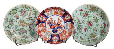 trois assiettes ornées de motifs floraux sont posées sur un présentoir