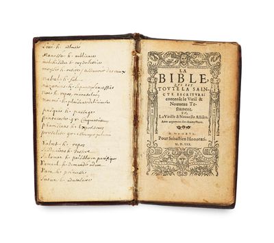 un vieux livre sur lequel on peut lire des mots, ouvert sur une surface blanche