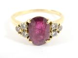 a close up of a ring with a pink stone surrounded by diamonds