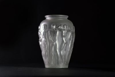 a glass vase sitting on a table with a black background
