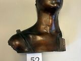 a bronze bust of a woman on display on the wall