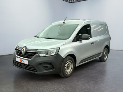 La camionnette grise est garée dans une pièce au sol noir.