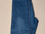 the pair of jeans are sitting on a table next to a pair of scissors