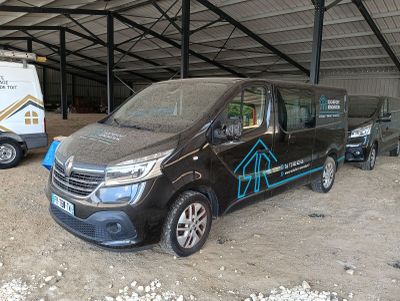 a van that is parked in a garage next to a truck