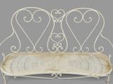 a white iron bench with two hearts on it