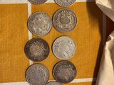 a lot of coins sitting on a table next to a bag