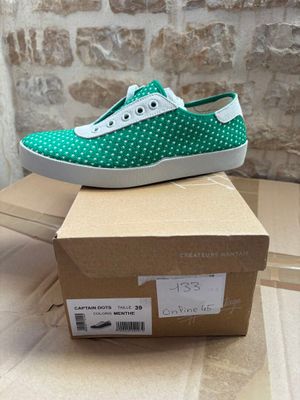 a pair of green and white shoes on top of a cardboard box