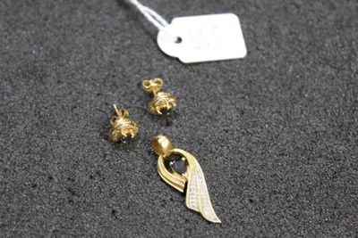 a close up of a pair of earrings and a tag on a table