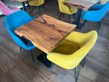 brightly colored chairs sit around a wooden table in a restaurant