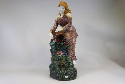 a figurine of a woman sitting on a rock