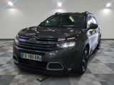La Citroën grise est garée sur un sol à damier dans un garage.