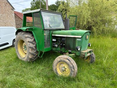 un tracteur vert garé dans l'herbe