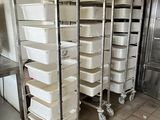 many trays of food sitting on a cart in the kitchen