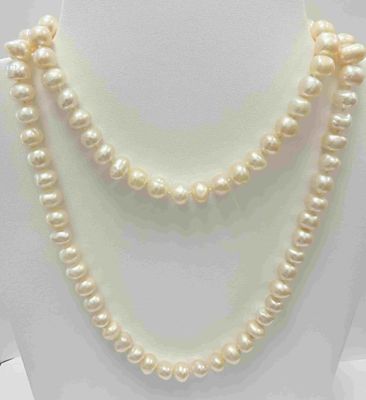 Le collier est composé de perles blanches et est présenté sur un mannequin blanc.