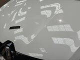 a close up of a white sports car parked in a showroom